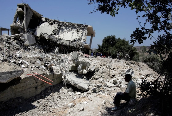 The remains of the house that was hit in an Israeli missile strike are seen in the village of Qana, southern Lebanon, on Monday. At least 56 residents of the village were killed when Israeli warplanes attacked the village early Sunday.