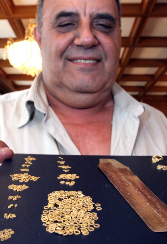 Bozhidar Dimitrov, the head of the Bulgarian National Museum of History, shows off a gold and platinum dagger, right, and pieces of jewelry believed to be 5,000 years old during a briefing in Sofia on Monday.