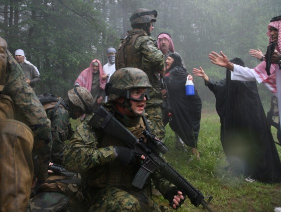 Sgt. Kristopher Schlueter, middle, participates in an urban combat drill with role players dressed as Iraqis, as Marines from the 4th Civil Affairs Group out of Anacostia prepare in Quantico, VA, to deploy to Fallujah, where the insurgency continues and anger among the civilian population remains high.