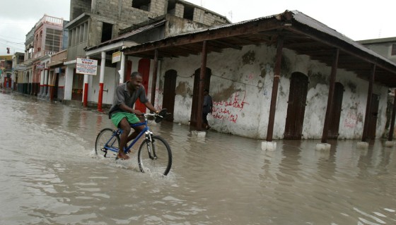 A man on a bicycle rides on a street flooded by heavy rains from Hurricane Ernesto in Les Cayes, Haiti, about 90 miles from Port-au-Prince.