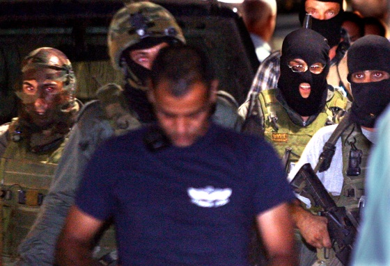 Israeli police walk with Palestinian man after capturing him inside the British embassy car park in Tel Aviv