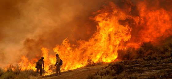 Firefighters light a backfire Wednesday near McLeod, Mont., as crews try to contain the Derby Mountain fire, now estimated to be 185,000 acres in size. 