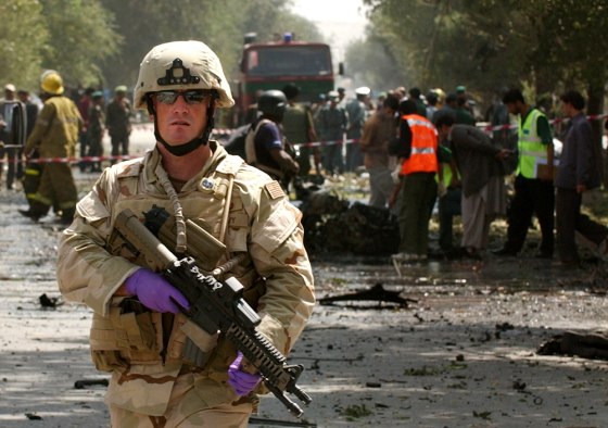 A U.S soldier stands guard at the bomb blast site near the U.S. Embassy in Kabul, Afghanistan, on Friday. A massive car bomb struck a convoy of U.S. military vehicles, killing at least 10 people, including two American soldiers.