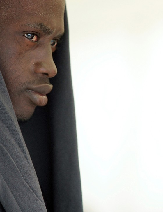 A would-be immigrant sits in a hospital tent in the port of Los Cristianos on the Canary island of Tenerife, Spain, on Tuesday, after 94 immigrants were intercepted at sea in their small boat.