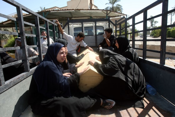 Iraqis mourn over the coffin of their relative as they take the body for burial from the hospital mortuary in Baghdad Wednesday. Police on Wednesday said they found the bodies of 65 men who had been tortured and then shot before being dumped around Baghdad.