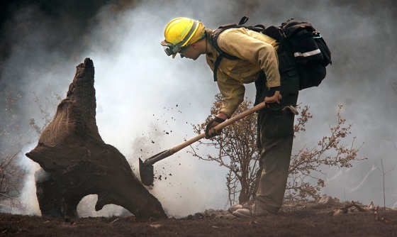 Rich Hayner of the Frenchtown, Mont., Fire Department tends to hot spots Thursday at the Montana fire that had grown to 32,000 acres.