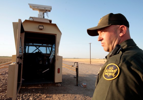A U.S. Border Patrol officer along the U.S.-Mexico border in Yuma, Ariz., stands outside a portable surveillance tower, known as Remote Video Surveillance Site.