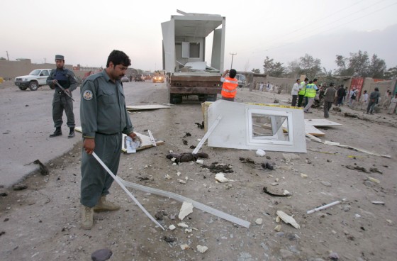 Afghan policeman investigates at a blast site in Kabul