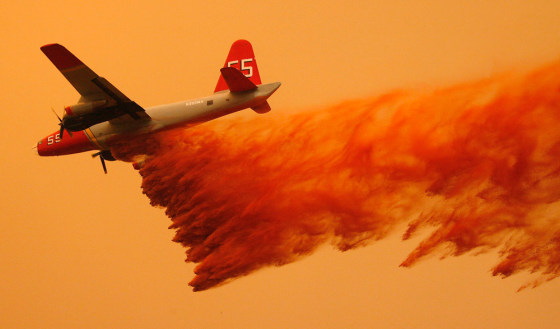 A California Department of Forestry air tanker drops fire retardant Sunday on the large fire burning near Ojai, Calif.