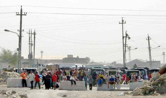 A group of Iraqi children look towards U.S. soldiers after throwing rocks at their position on the edge of Sadr City in Baghdad on Monday.