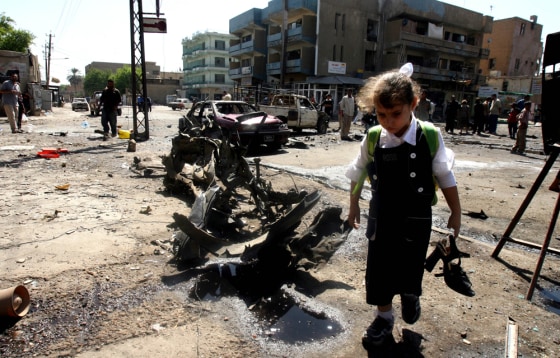 An Iraqi girl takes home her older sister's shoes from a site near Abu Tibeekh restaurant in Sadoun Street in central Baghdad where a car bomb explosion killed five people and wounded 34 Thursday. It was unclear if her sister was injured in the attack.