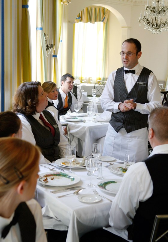 Commander's Palace waiter Chris Sander practices ahead of the restaurant's reopening in New Orleans on Wednesday. The Creole fixture will welcome patrons back on Sunday.