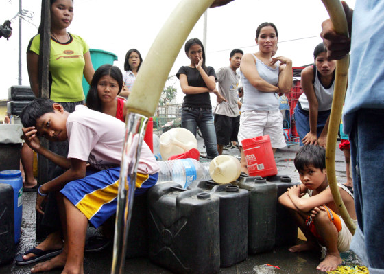 Residents line up to get water on Saturday in Manila, Philippines, two days after Typhoon Xangsane hit the city, cutting off water and electricity supplies.