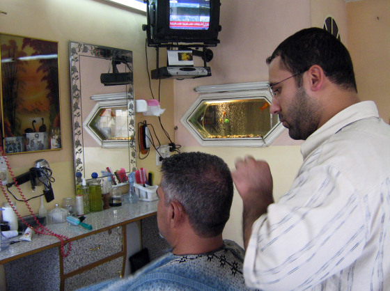 Ali Abdul is seen cutting the hair of Abdul Razak, a resident of Tobji, Iraq, on Tuesday.
