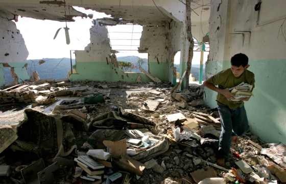 Hussein Dakdouk, 19, gathers books in a destroyed mosque in the southern city of Aita Al-Shaab, Lebanon, on Sept. 24. Aita Al-Shaab's was heavily bombed by Israeli forces during the war with Hezbollah fighters.