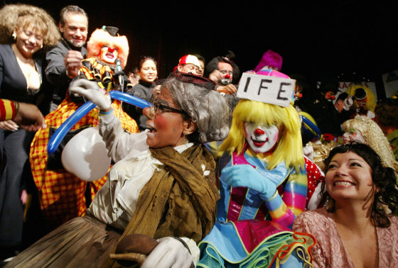 Clowns and guests burst balloons to kick off the Latin American Clown Convention at the Venustiano Carranza theatre on Monday in Mexico City.