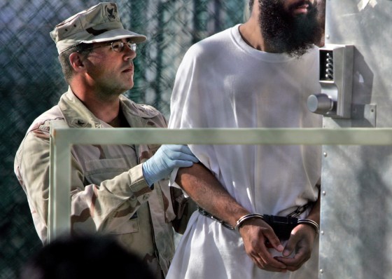 In this April 2006 file photo, a shackled prisoner is moved at the Guantanamo Bay naval base, Cuba. Guantanamo is under renewed scrutiny after a U.S. Marine said she heard guards boast about beating detainees. Guards, in turn, say detainees often threaten them.