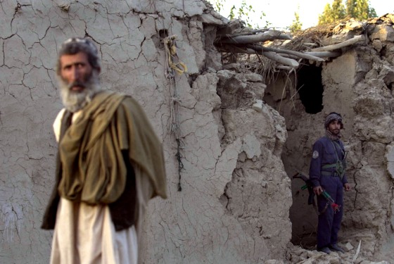 An Afghan policeman stands Wednesday inside a mud-brick house damaged during a NATO airstrike. Residents said five children, five women and three men were killed.