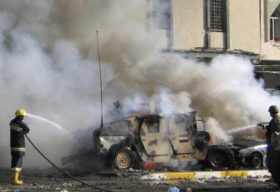 Firemen hose down an Iraqi armoured vehicle after a suicide car bomb attack in Kirkuk