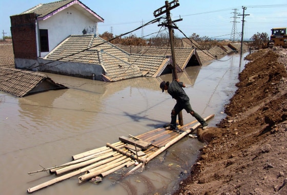 A villager steps on a bamboo raft at a s