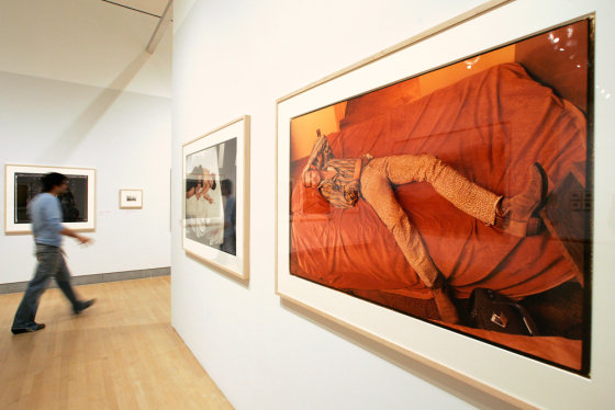 A member of the press walks past a portrait of Brad Pitt, left, and one of Kate Moss and Johnny Depp during the press preview for 'Annie Leibovitz: A Photographers's Life, 1990-2005' Oct. 19th at the Brooklyn Museum. The exhibit runs through Jan. 21.