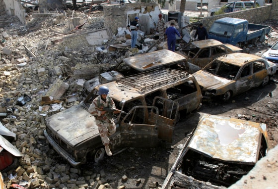 An Iraqi soldier stands guard Saturday outside an Amarah police station that was destroyed in fighting the previous day.