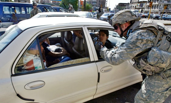 A US soldier searches a car at a snap ch