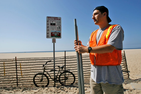 Howard Shapiro arranges poles to build an "eruv," a symbolic religious enclosure for Orthodox Jews, on the boardwalk of Venice Beach in Los Angeles. 