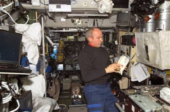 NASA astronaut Jeff Williams checks out a food pouch in the international space station's galley. Meals cooked up by chef Alain Ducasse were on board a cargo ship headed for the space station.