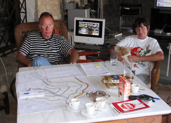 Hubert van Bel, left, and Lieve de Cleippel sit in their home in Valencia, Spain. The map laid out on the table in front of them shows how a developer planned to build 17 houses on their property, which the town rezoned for urban development without notifying them.