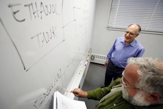 Leslie Bromberg draws an outline of a new car engine as his colleague Daniel R. Cohn watch at the Massachusetts Institute of Technology in Cambridge