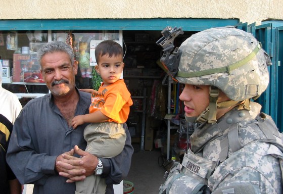 Capt. Adam Sawyer, 28, of Reading, Pa., speaks with Samir Hassan, 53, a storeowner in the small village of Mustafar, Iraq, about how to improve security there. Sawyer's regiment is working to improve services in towns south of Baghdad as part of an effort to win over the local population and to get them to trust Iraqi security forces.