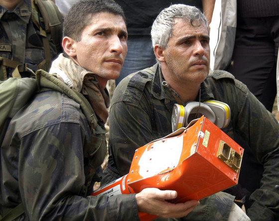 In this picture released by the Brazilian Air Force, two soldiers retrieve the flight data recorder of the Gol airlines Boeing 737-800 that crashed on Sept. 29.