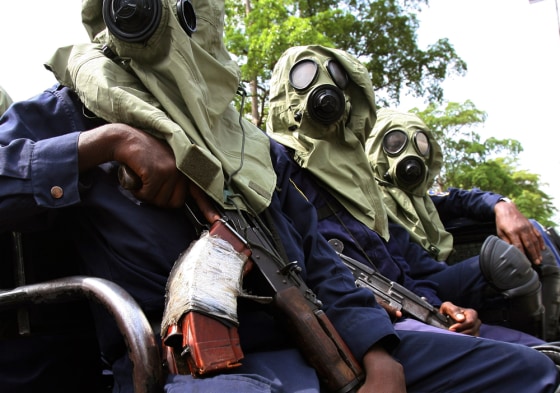 Congolese riot police in gasmasks ride on a vehicle along the streets of Kinshasa