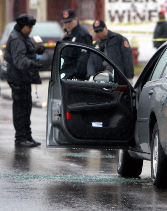 Police look over the shooting scene in west Detroit after a series of shootings that killed two people and wounded three others in the span of 10 minutes on Thursday morning.