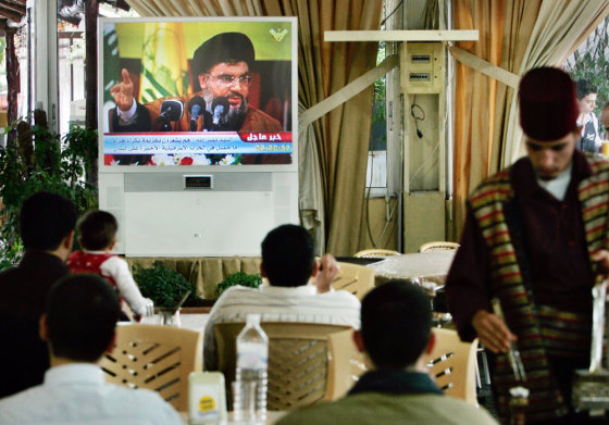 Visitors to the Sweet Land amusement park watch Hezbollah leader Hassan Nasrallah deliver a speech Sunday calling for mass demonstrations against the Lebanese government.