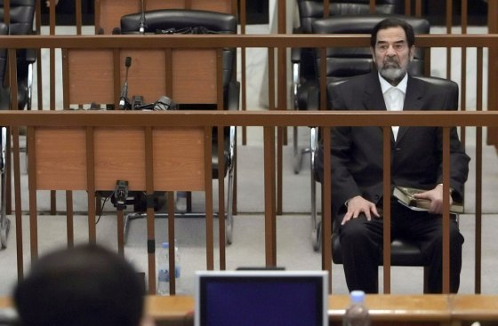 Former Iraqi leader Saddam Hussein sits in the dock during his trial inside the heavily fortified Green Zone in Baghdad