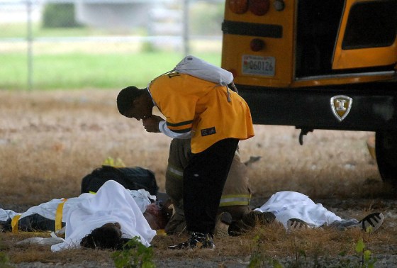 A student leans over another student from a school bus that veered off an interstate and crashed below an overpass on Monday, in Huntsville, Ala.