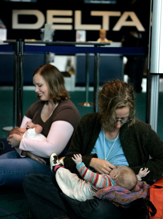Marnie Glickman, right, breast-feeds her daughter, Calliope, while Rachel Brusseau breast-feeds her son, James, in front of the Delta Airlines gate at Portland International Airport in Portland, Ore., on Tuesday. Approximately 35 mothers with children showed up in support of a woman that was removed, along with her family, from a Delta flight in Vermont for breast-feeding her child.