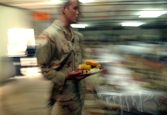 A U.S. Army 82nd Airborne Division soldier takes his Thanksgiving meal at a base in Baghdad in 2003. Many service members who are away from home on service within the United States are invited to spend the holiday with host families.