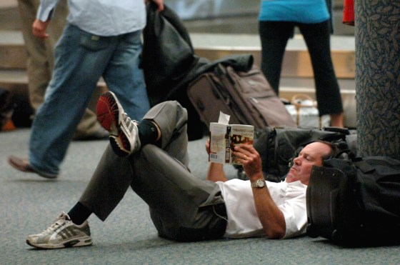 Wayne Defrancesco of Baltimore reads in the baggage claim area of the Palm Beach International Airport on Sunday.