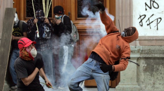 Protester throws teargas canister at federal police during clashes between demonstrators and federal police in Oaxaca