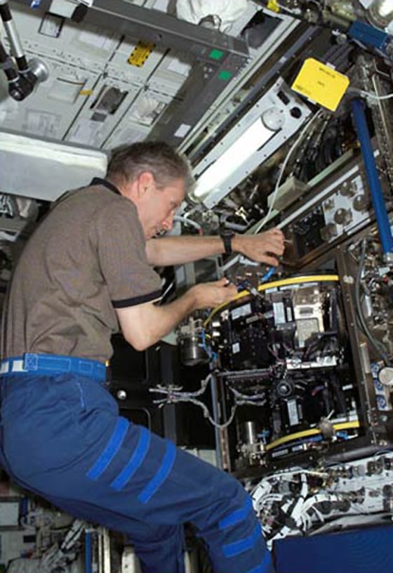 ESA astronaut Thomas Reiter works with the European Modular Cultivation System aboard the International Space Station. Astronauts aboard the space station are studying how zero gravity effects plant growth and human sleep patterns, among other experiments. 