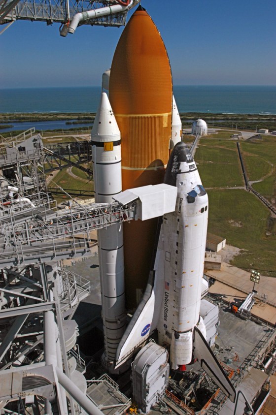 The shuttle Discovery's brick-red external fuel tank stands out in this view of Launch Pad 39B at NASA's Kennedy Space Center. NASA says it has decided to wait until 2008 to redesign the tank.