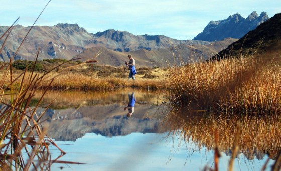 A hiker passes by a small lake in the Swiss Alps near Stels, Switzerland, in late October as the region marked an unusually warm fall season.