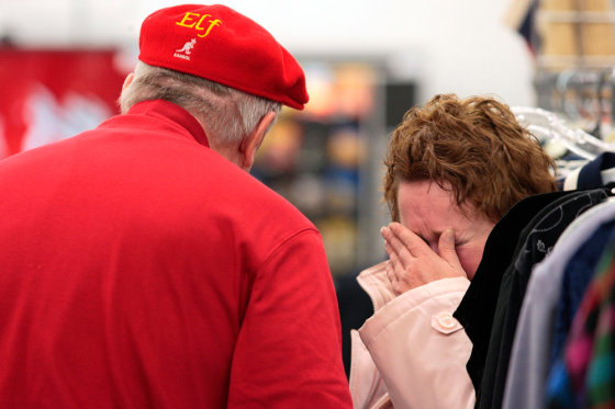 Diana Ankrom weeps as a Secret Santa from Kansas City hands her and her mother $100 bills at the Salvation Army Store on South High Street in Columbus, Ohio, late Wednesday.