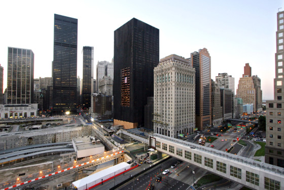 Shrouded in a web of black netting, the vacant former Deutsche Bank building looms over the World Trade Center site in this Sept. 11, 2005, file photo. Workers began the difficult task of dismantling the skyscraper on Friday.