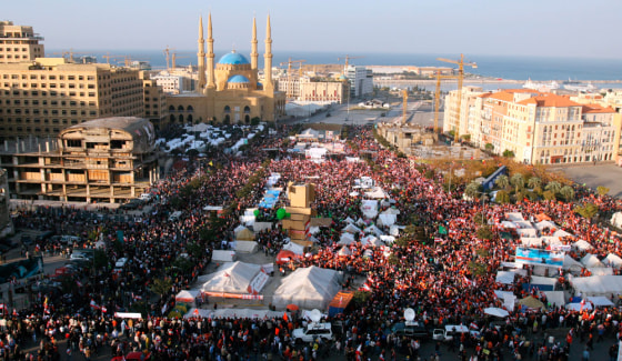 Lebanese protesters wave national flags during a mass rally called by the Hezbollah-led opposition in central Beirut