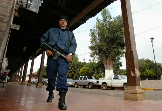A police officer walks in the Central State of Michoacan, Mexico on Monday, part of a force of more than 6,500 soldiers and police sent by Mexico's new government to the western state of Michoacan to crack down on execution-style killings.