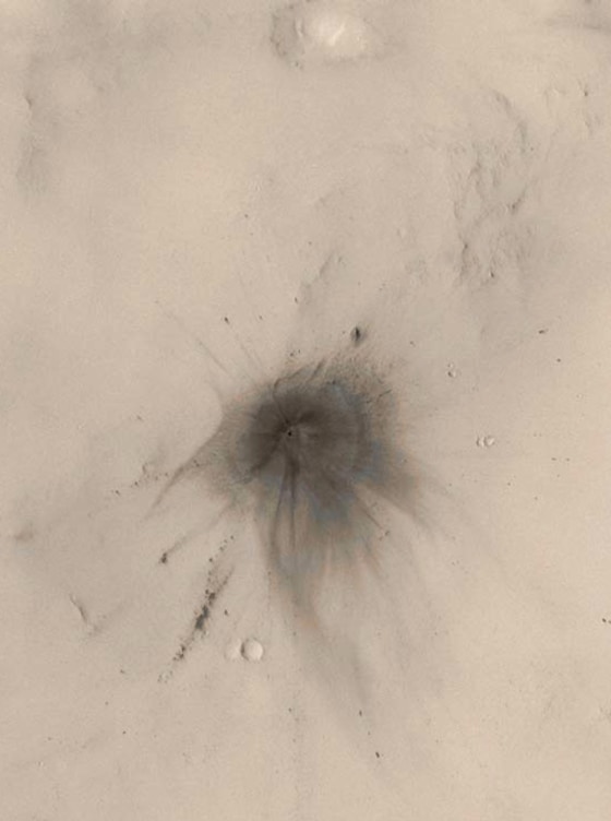 Wispy dark rays and dark, annular (nearly-circular) zones surround a newfound Mars crater. Scientists used the Mars Orbiter Camera to photograph about 30 percent of the planet.